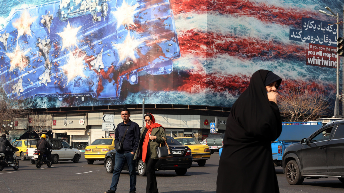 Иранци минават покрай огромен антиамерикански билборд, окачен в Техеран, 27 януари 2026 г.