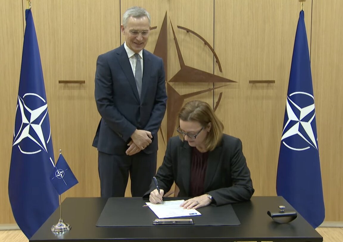 Генералният секретар на НАТО Йенс Столтенберг наблюдава подписването на договора от Стенси Къмингс.