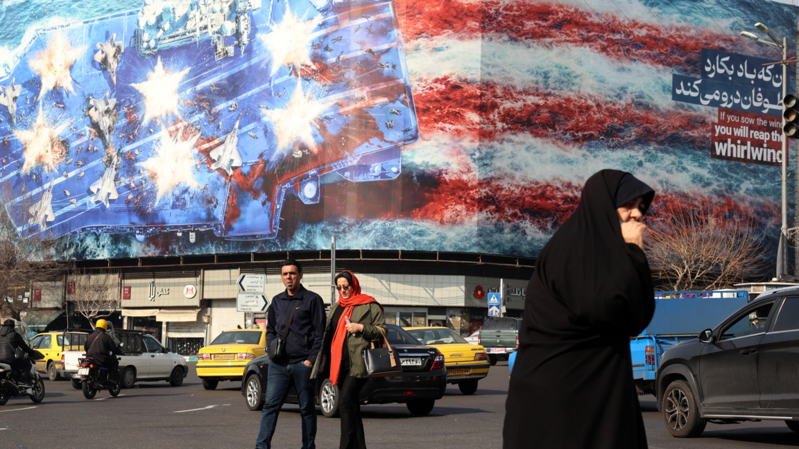 Иранци минават покрай огромен антиамерикански билборд, окачен в Техеран, 27 януари 2026 г.